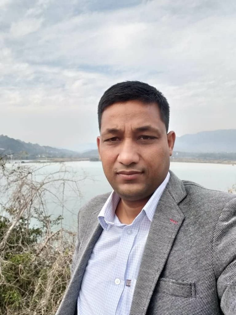 Portrait of Dr. Kapoor wearing traditional attire with academic books in background